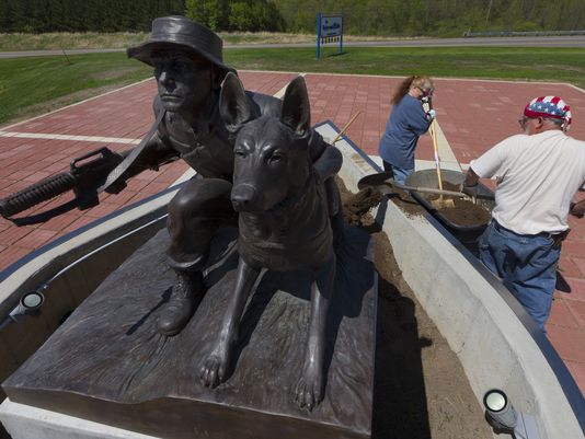 Volunteers Dan and Loretta Scheunemann perform landscaping work around a memorial dedicated to military dogs and their handlers at Highground Veterans Memorial Park outside of Neillsville. The memorial will be officially dedicated June 2